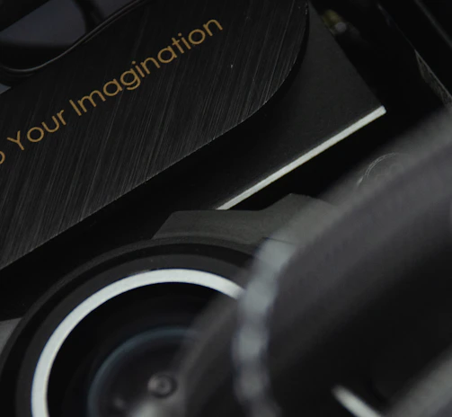 A close-up view of a mechanical or technological component with a sleek design and metallic textures is displayed. The phrase 'Power Up Your Imagination' is etched on the surface, suggesting encouragement or inspiration, possibly for creative or innovative activities.
