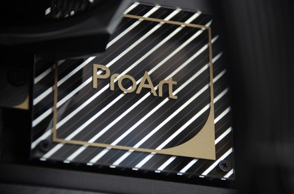 a close up of a black and white object with gold lettering
