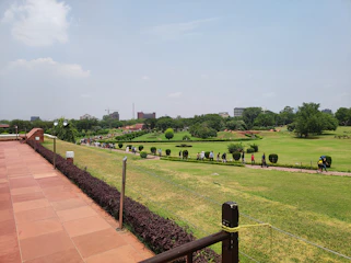 A group of prospective buyers walking through wide internal roads surrounded by green landscaped gardens.