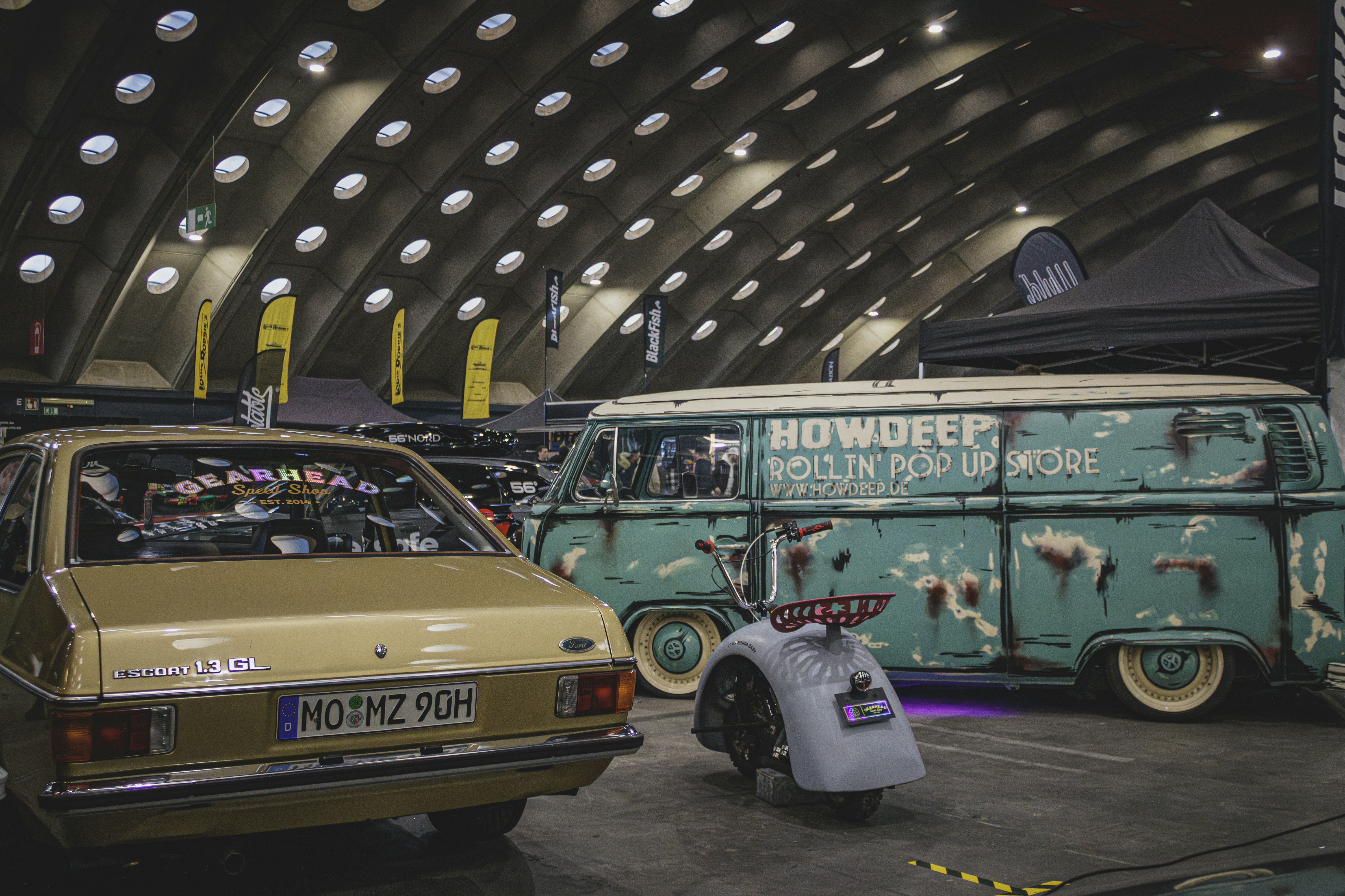 a car and a van are on display in a museum