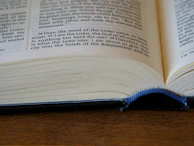 An open book with a bookmark featuring a website address.