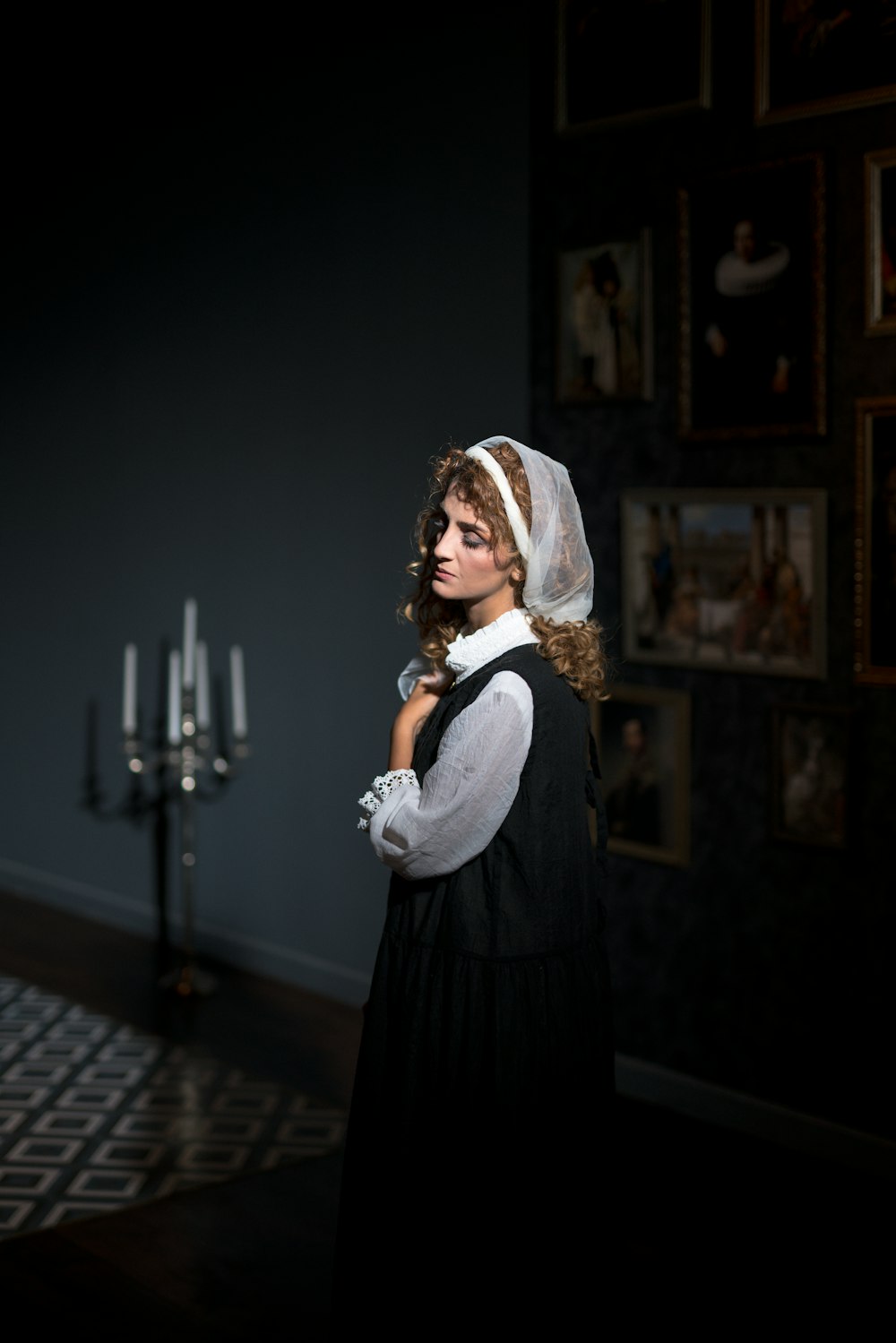 a woman in a dress and veil standing in a dark room
