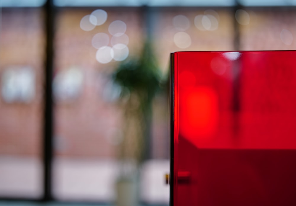 a red refrigerator sitting in front of a window