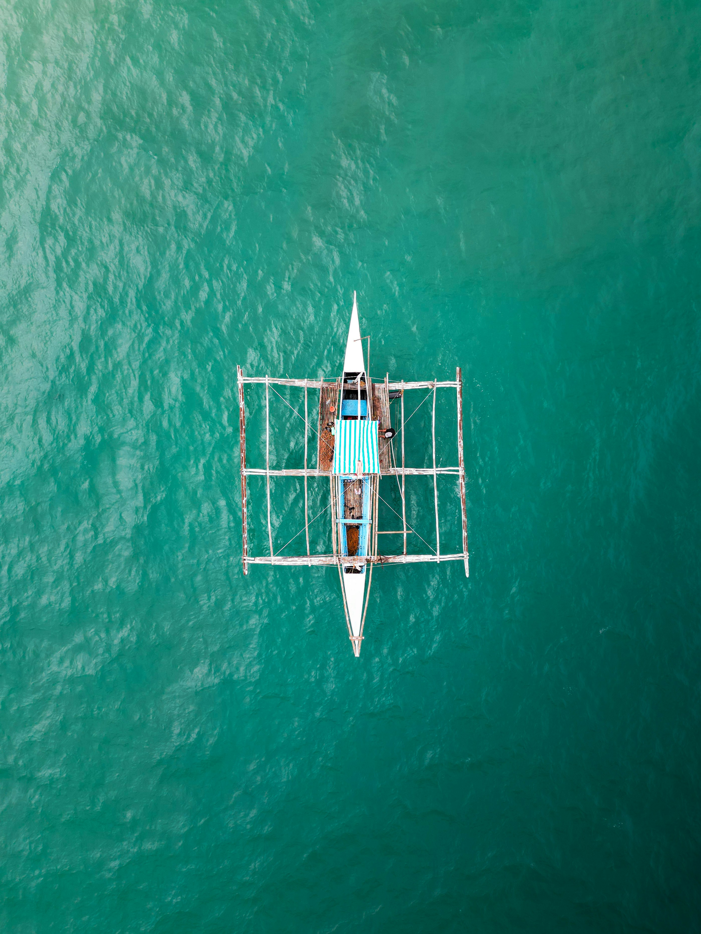 A person in a boat in the middle of the ocean photo – Free Sea Image on ...