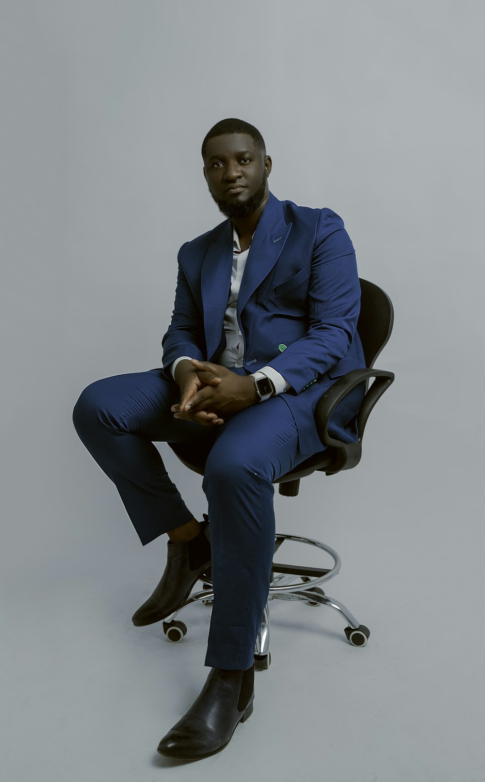 a man in a blue suit sitting on a chair