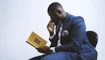 a man in a blue suit is reading a book
