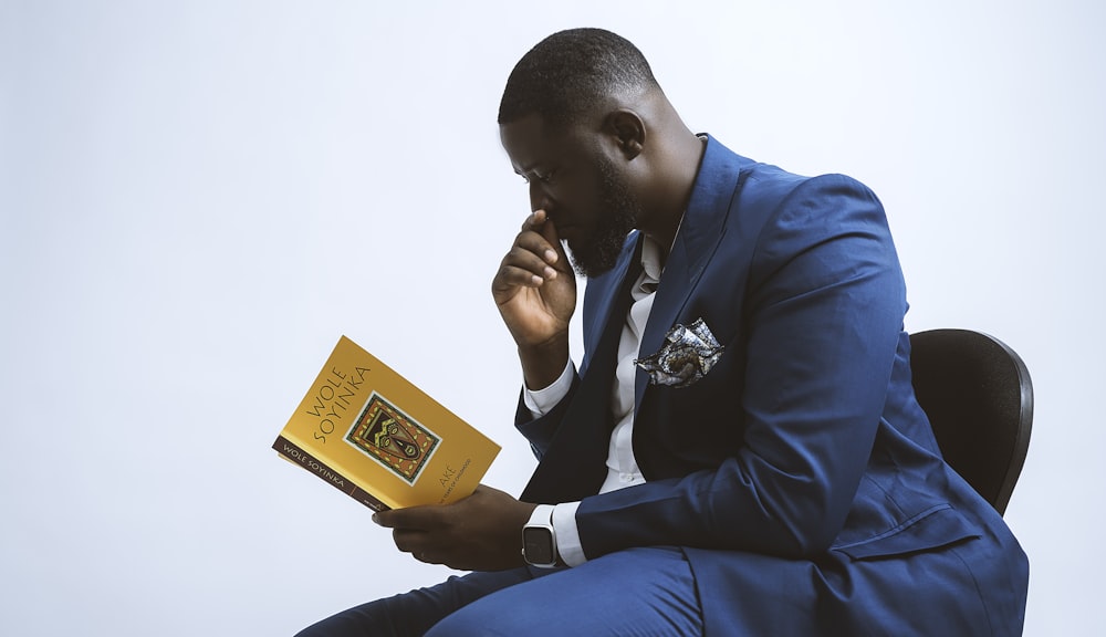 a man in a blue suit is reading a book