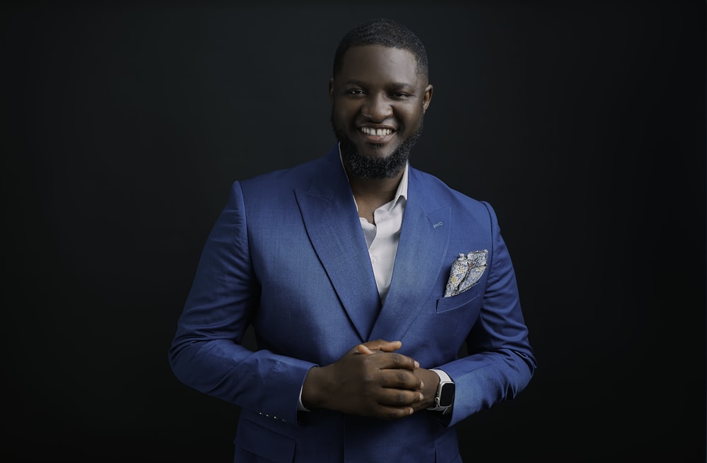 a man in a blue suit smiling for the camera