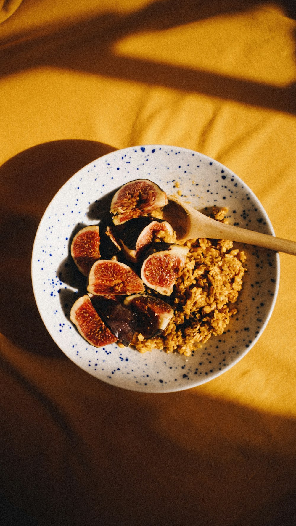 a bowl of cereal and figs on a table