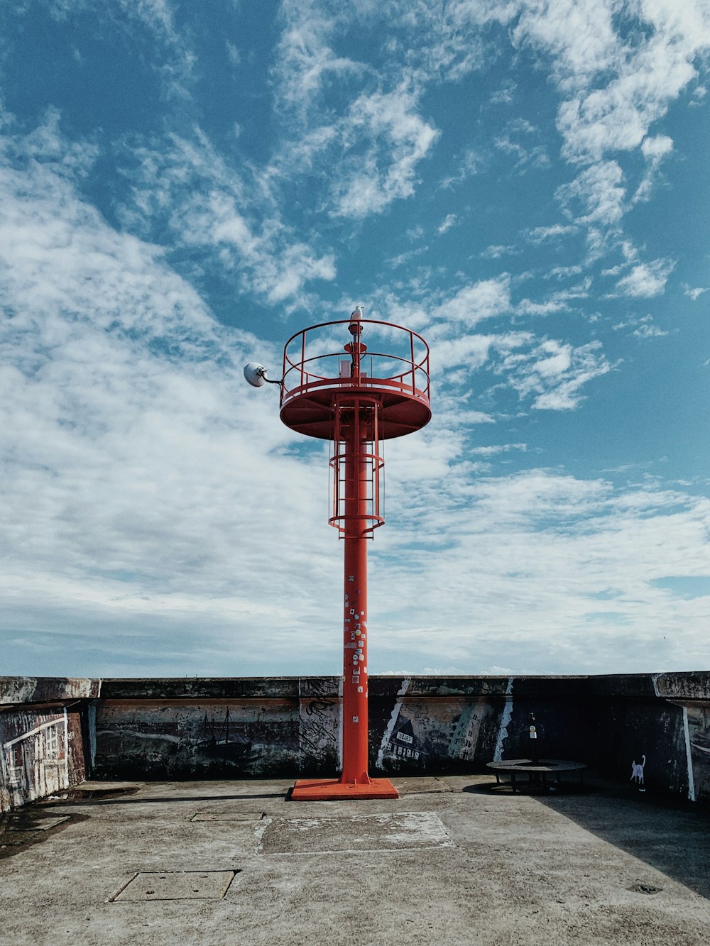 a red fire hydrant sitting on top of a cement ground