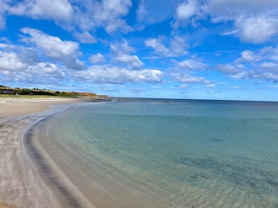 A tranquil beach with clean sand and gentle waves.