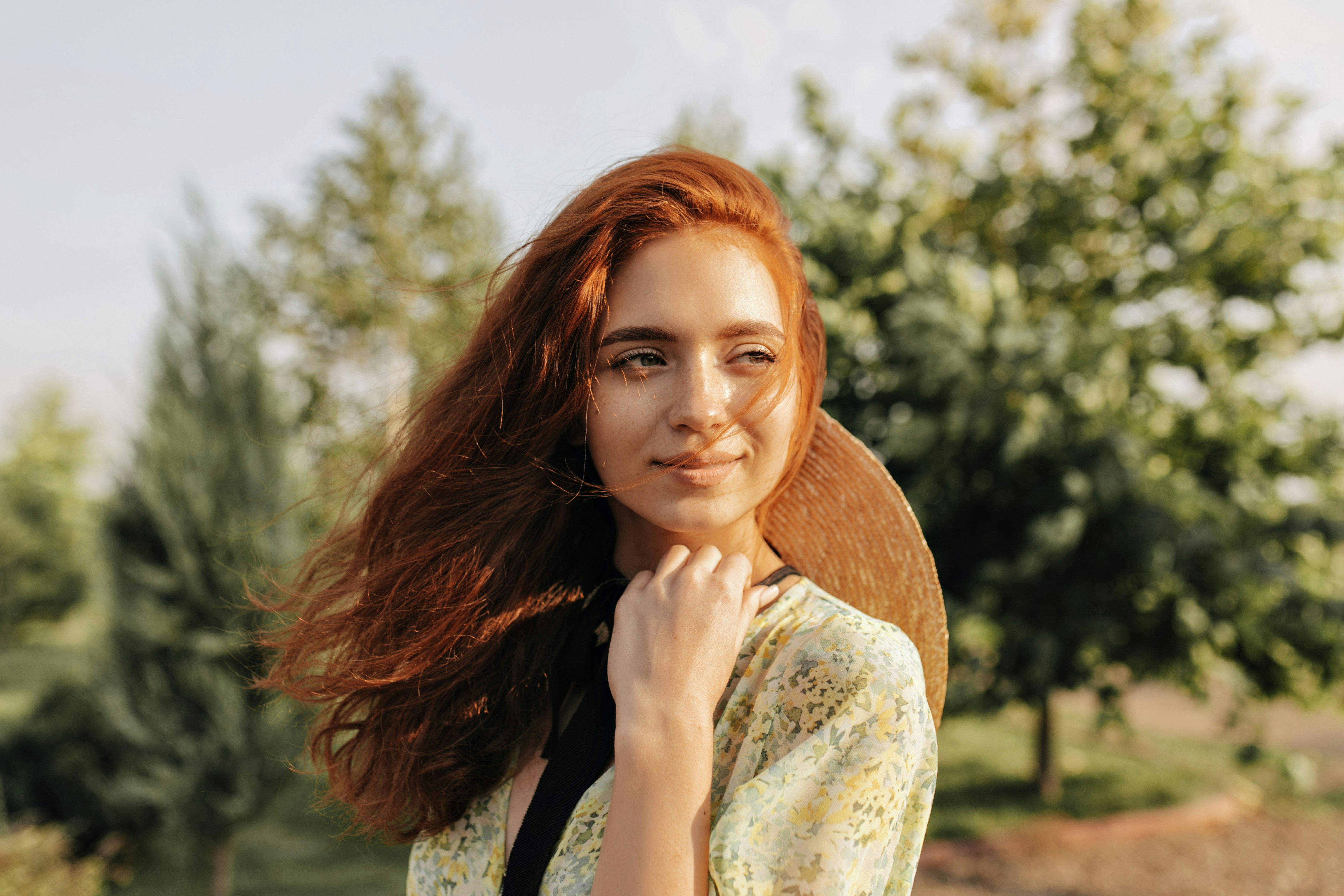 A woman with long red hair posing for a picture