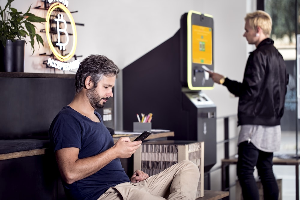 a man sitting on a bench using a cell phone