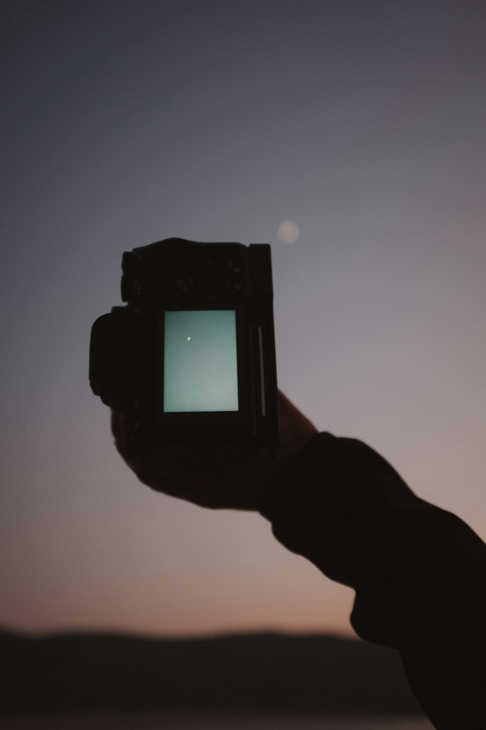 a person holding up a small screen in their hand