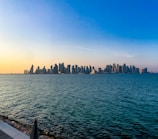 A panoramic view of a modern city skyline at sunset.