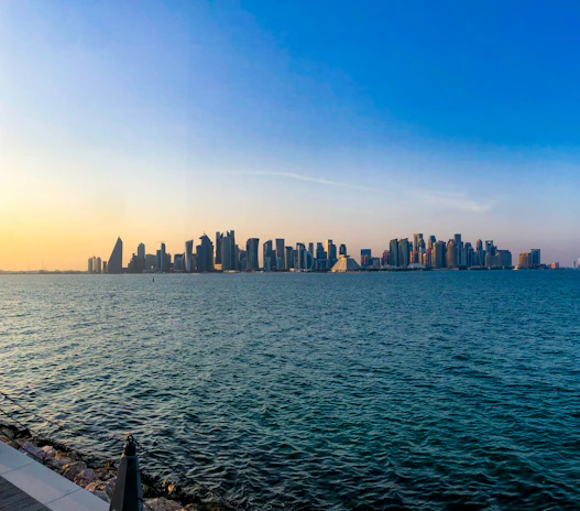 A panoramic view of a modern city skyline at sunset.