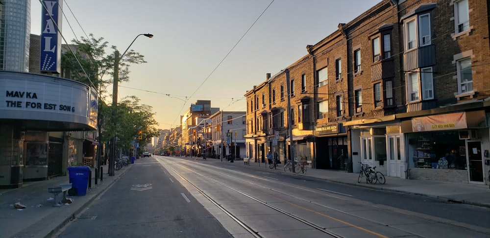 a city street with buildings and a train on the tracks