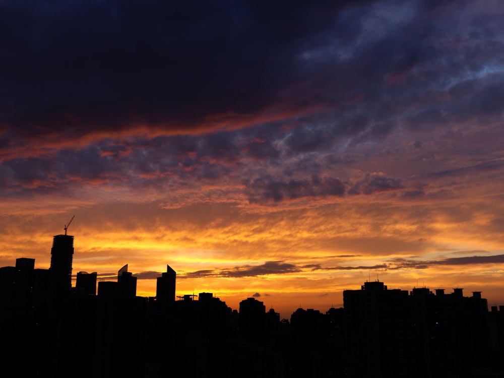 a sunset view of a city with tall buildings