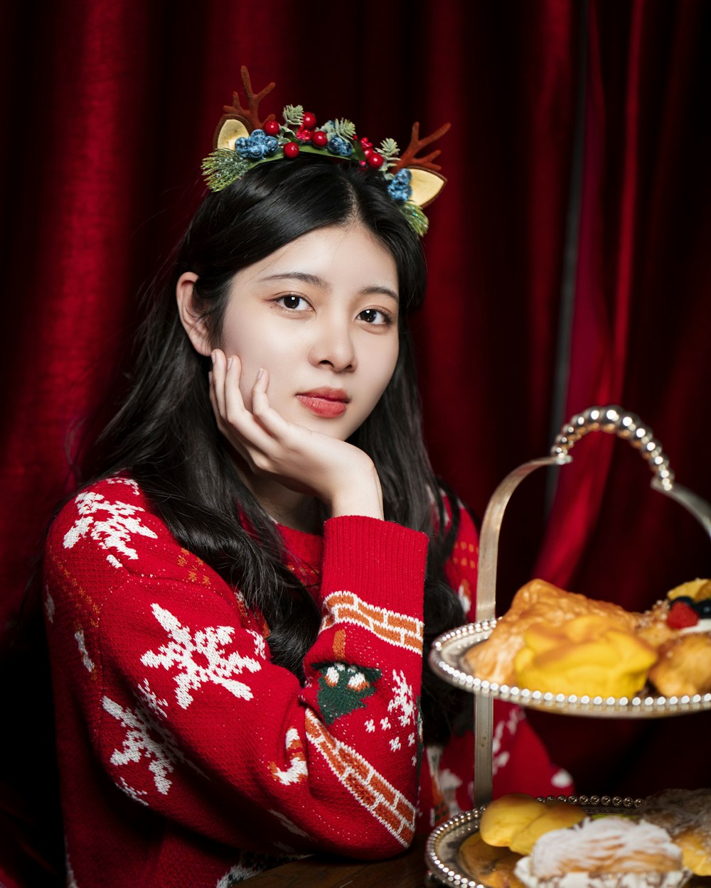 a woman in a red sweater is holding a tray of food