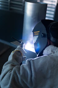 a man welding a piece of metal on a machine