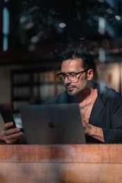 a man sitting at a table using a laptop computer