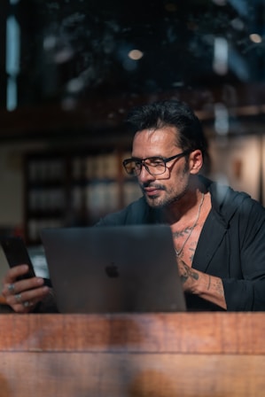 a man sitting at a table using a laptop computer
