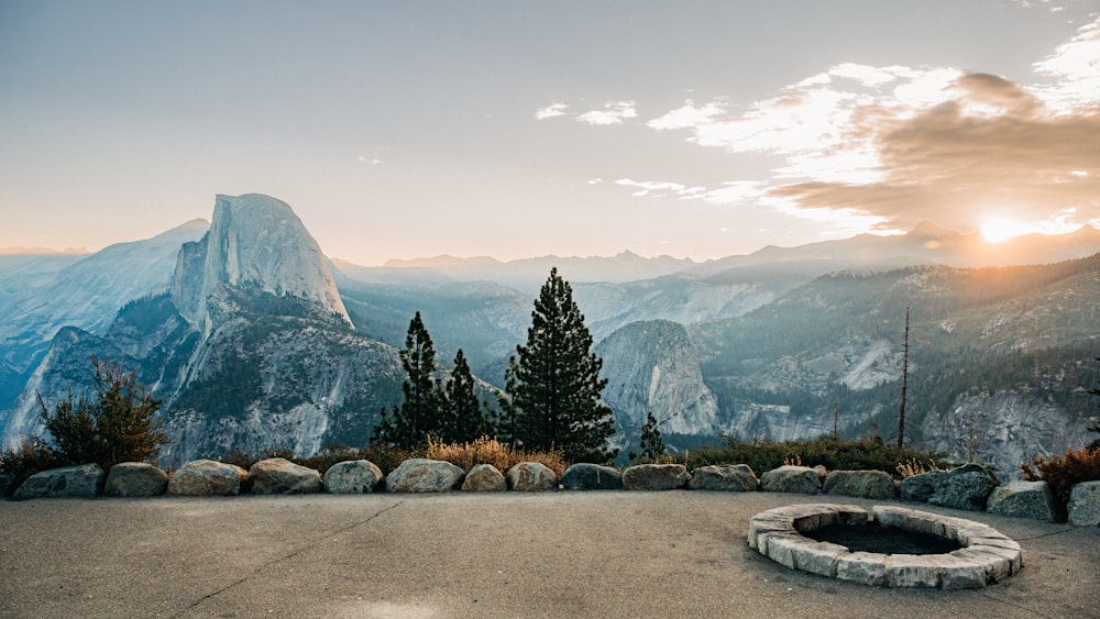 a view of a mountain range with a fire pit in the foreground