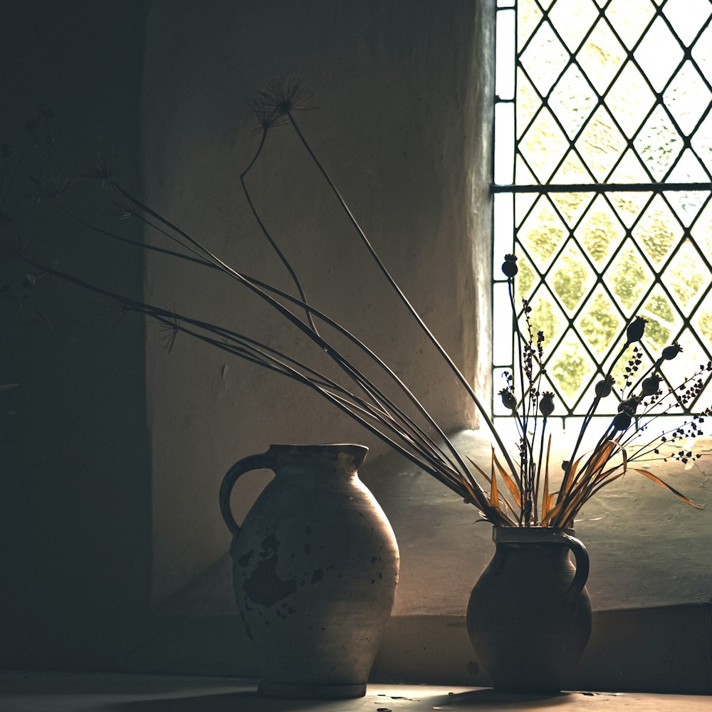 a couple of vases sitting next to a window