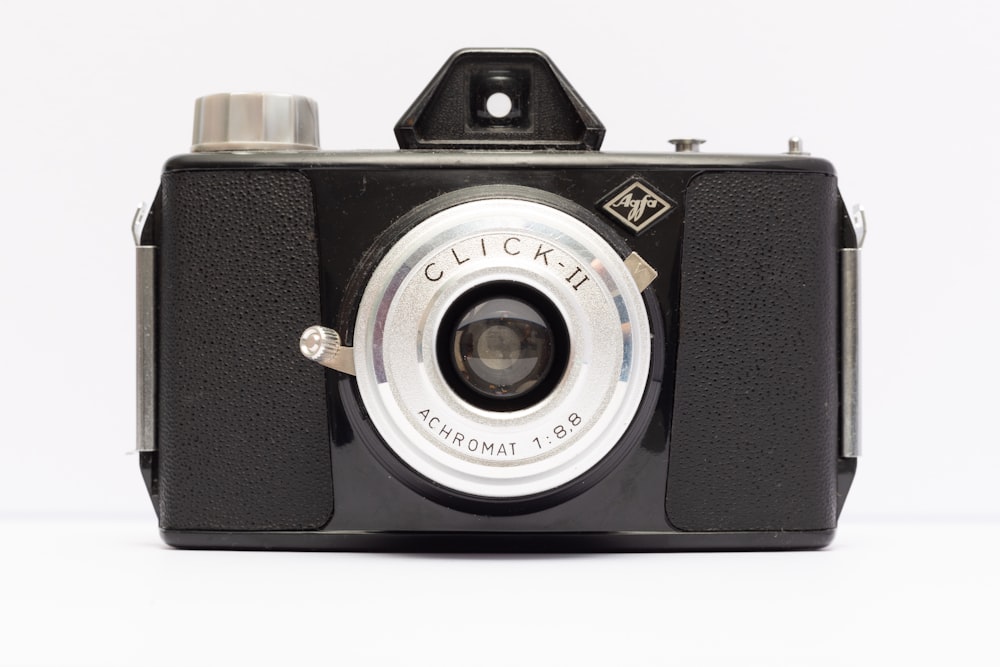 an old black camera with a white background