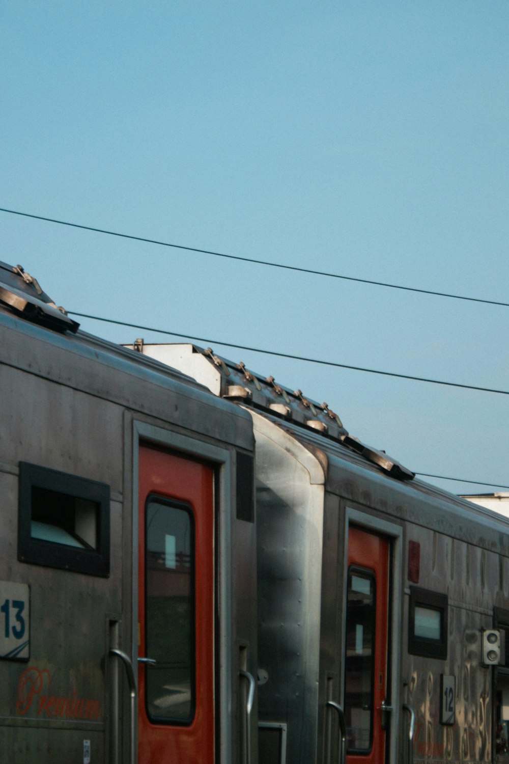 a silver train with a red door is on the tracks