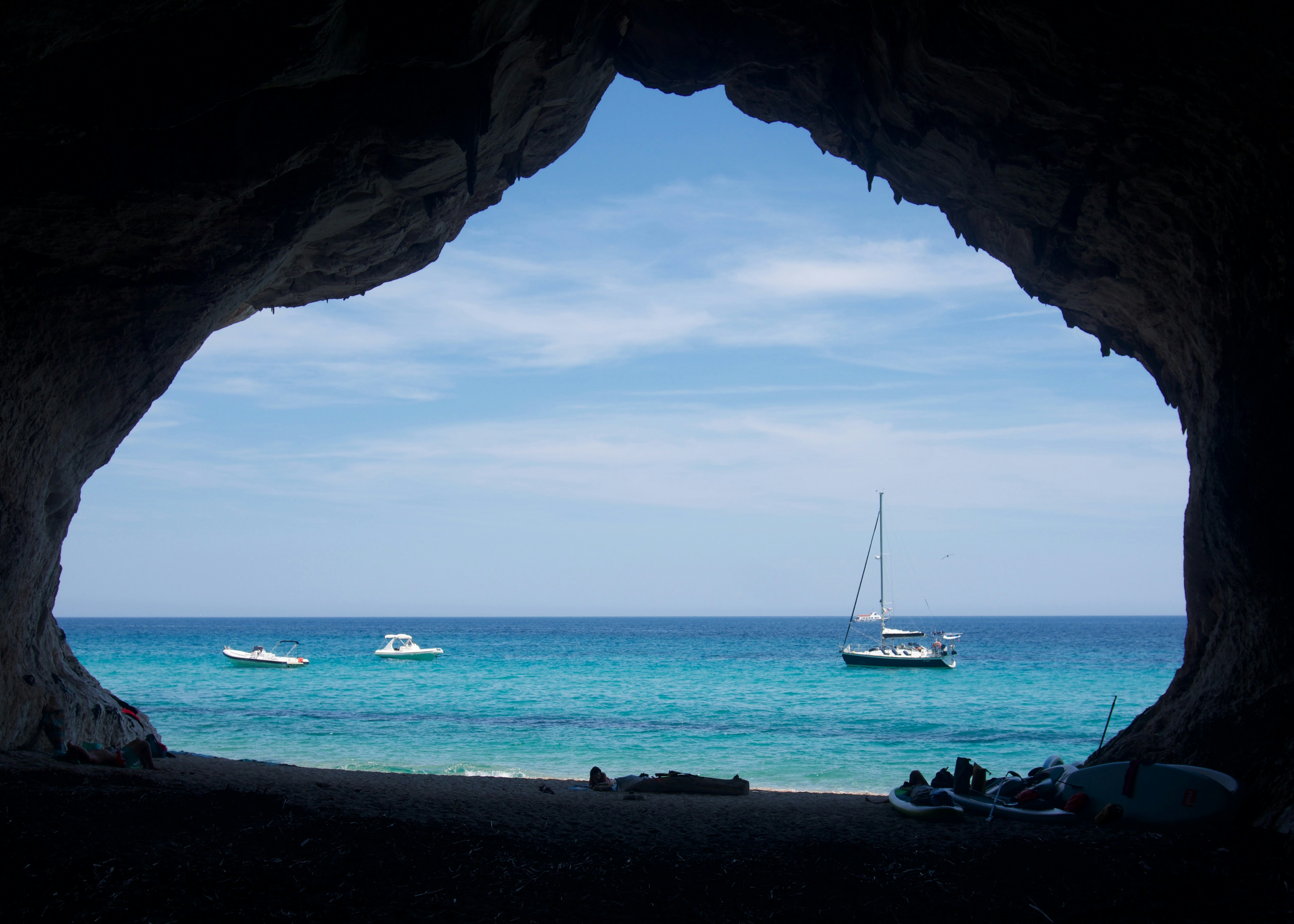 a boat is in the water through a cave, 