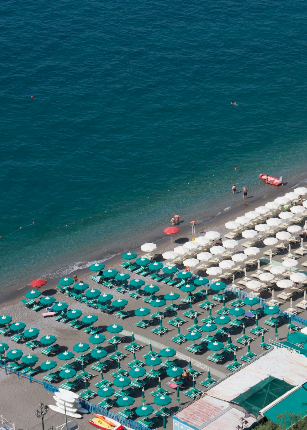 an aerial view of a beach with umbrellas and chairs