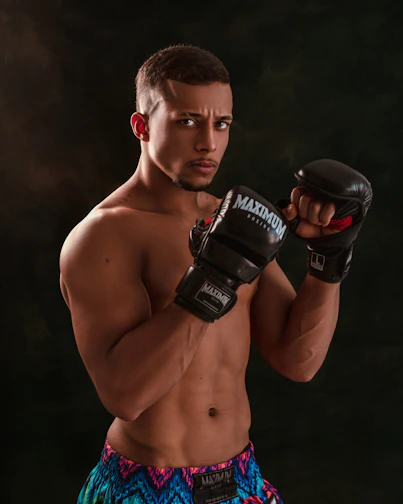 Close-up of a fierce fighter wearing a Combat Club Shop hoodie, fists wrapped and ready.