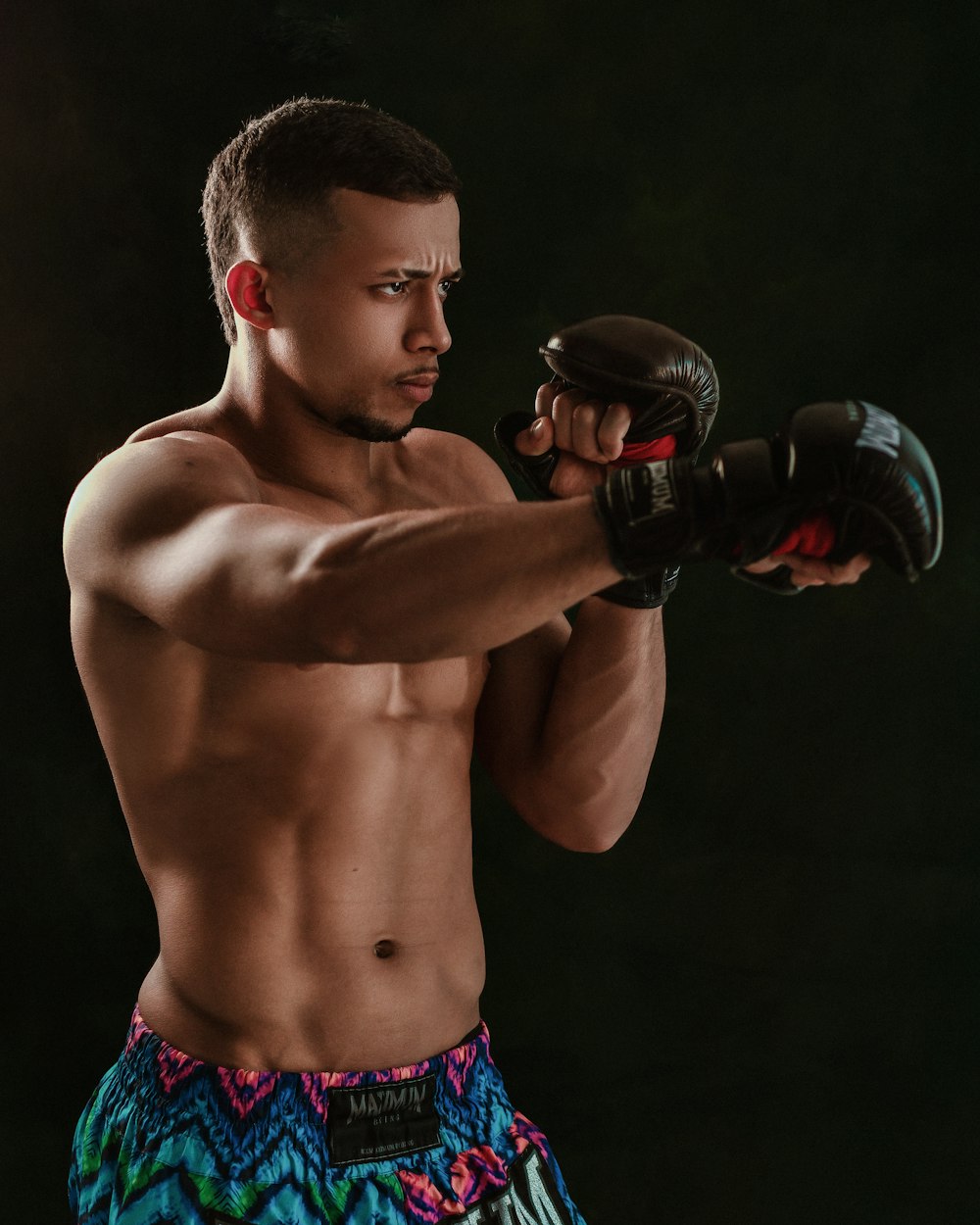 a shirtless man wearing a pair of boxing gloves