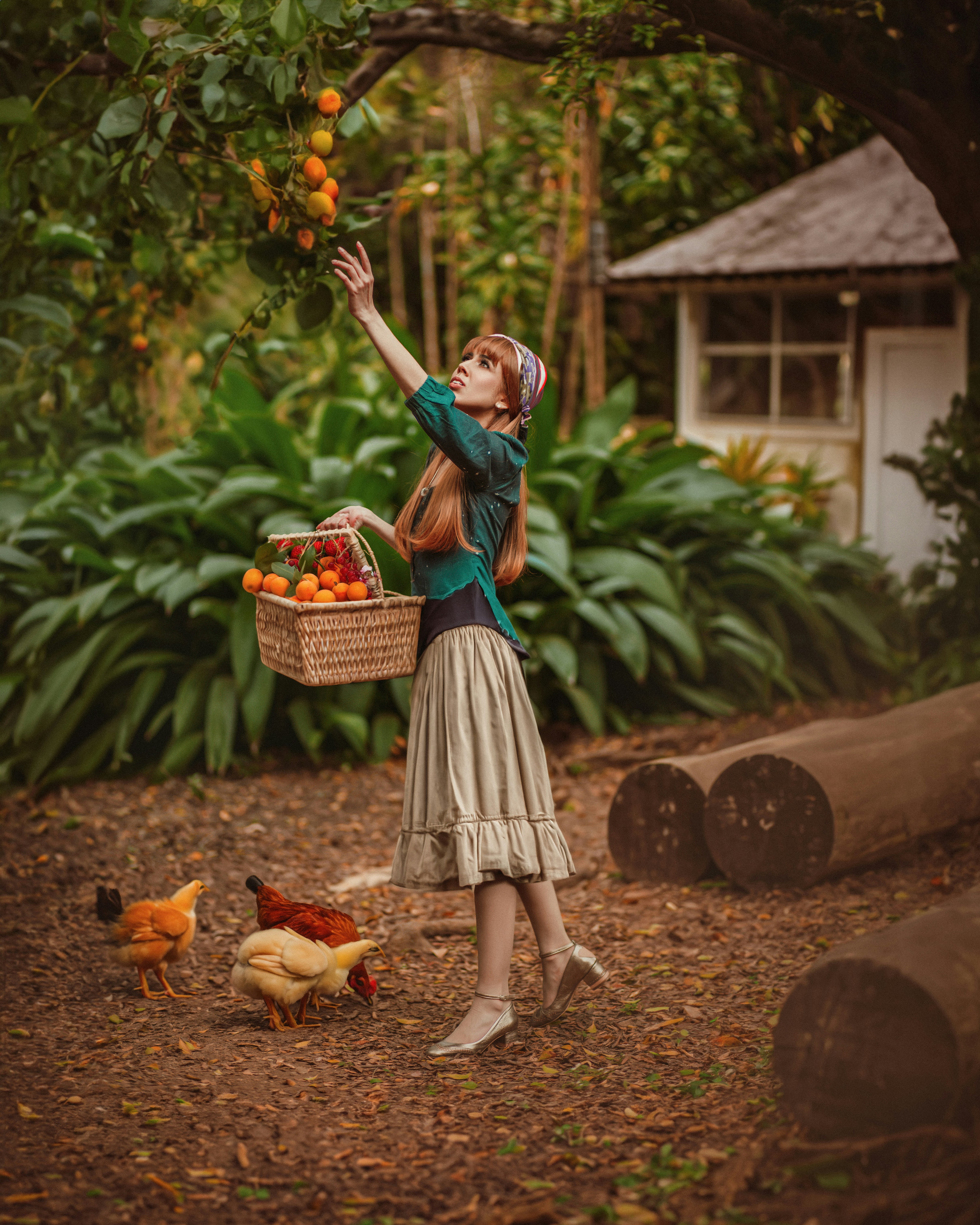a woman holding a basket of fruit while standing next to chickens