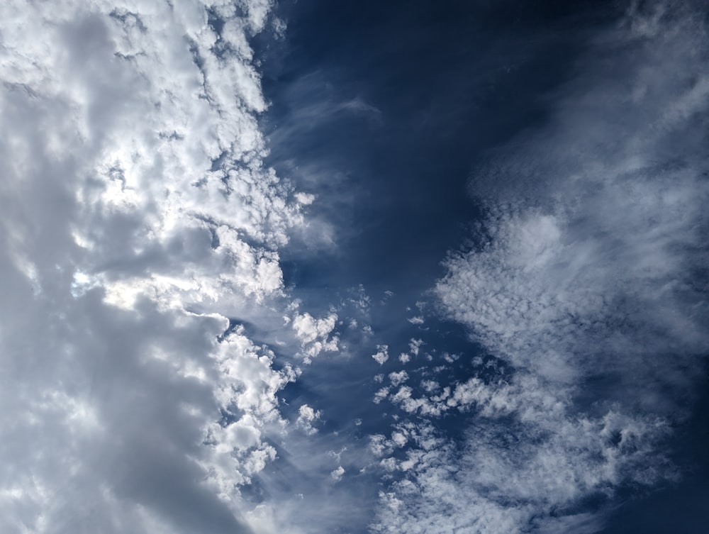 Un avión volando a través de un cielo azul nublado