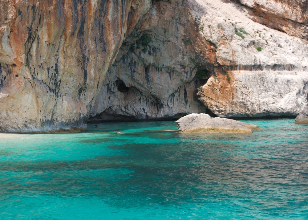 a body of water near a rocky cliff