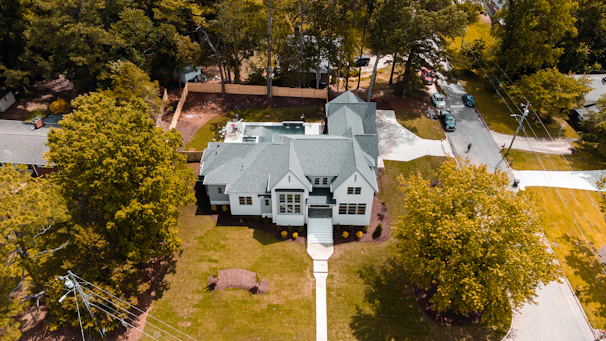 an aerial view of a large house surrounded by trees