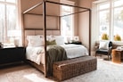 a bedroom with a four poster bed and a wicker trunk