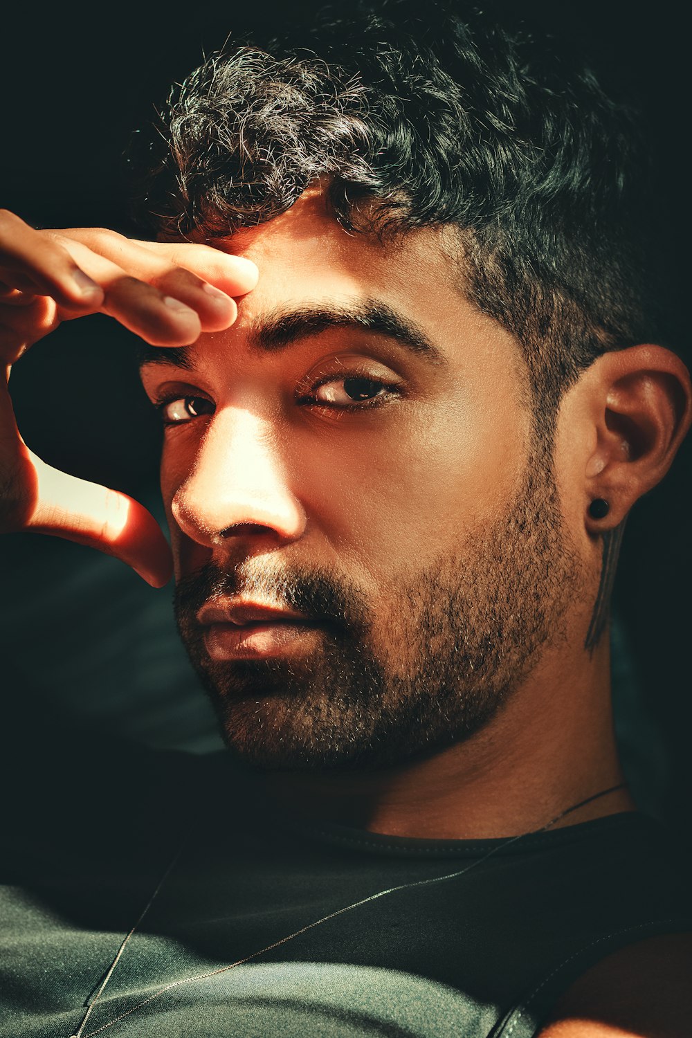 a close up of a person holding his hand near his face