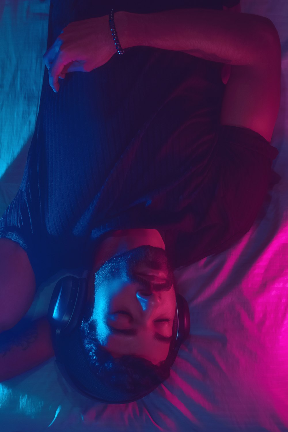a person laying on a bed with headphones on
