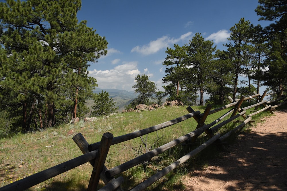 a wooden fence in the middle of a field