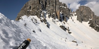 A close-up of a chilled Aqua di Monte bottle with dew drops, set against a backdrop of snow-capped Himalayan peaks.