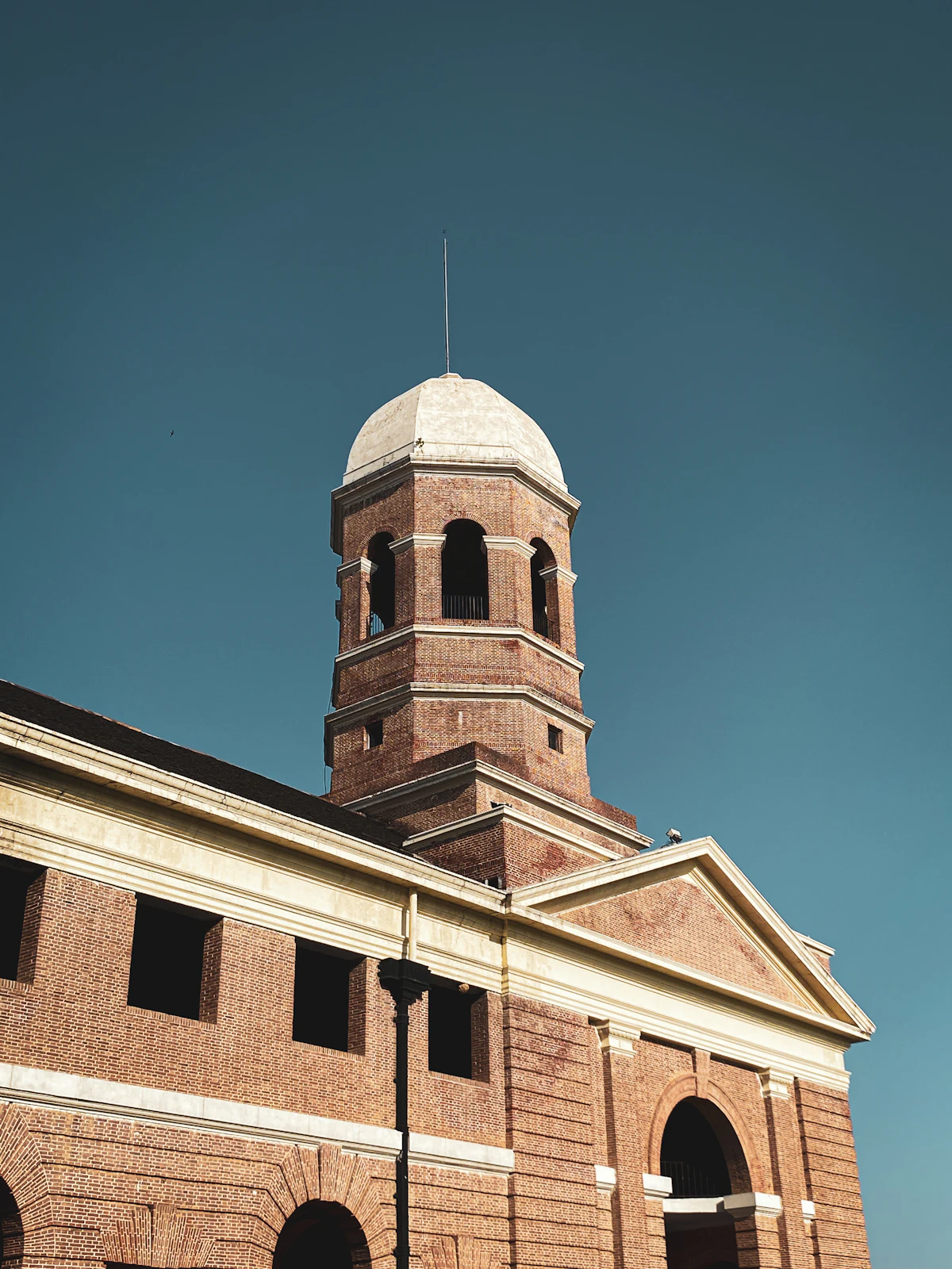Brick clock tower building in Dehradun under a clear sky
