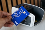 a person is holding a blue credit card