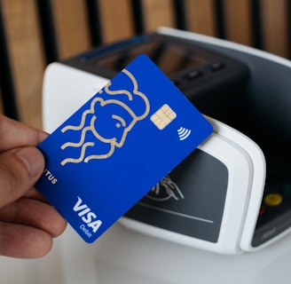 a person is holding a blue credit card