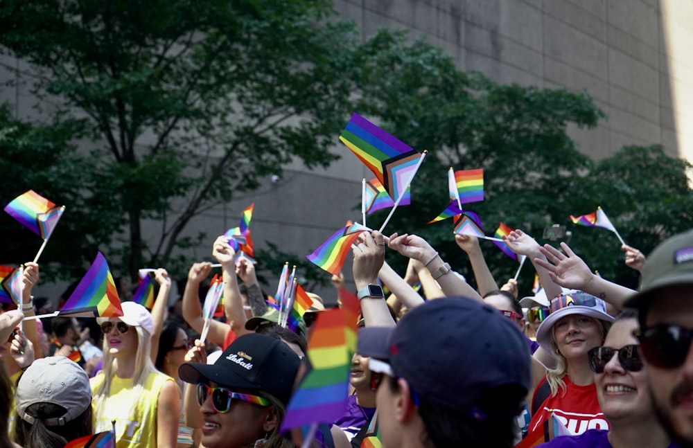 Un gran grupo de personas sosteniendo banderas del arco iris