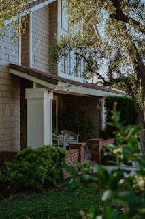 the front of a house with a large tree in front of it
