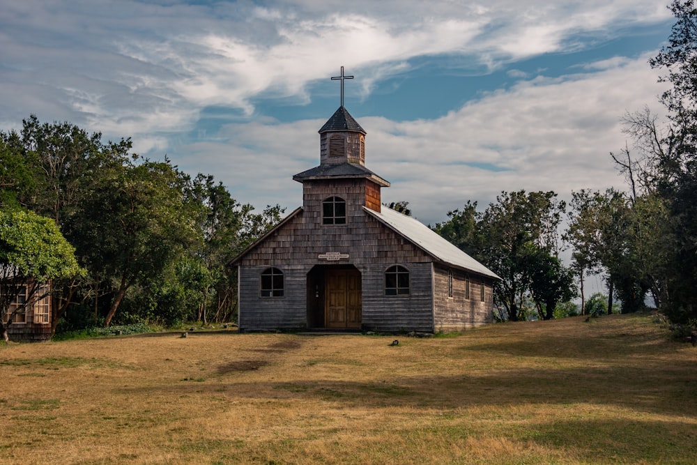 an old wooden church with a steeple and a cross on top