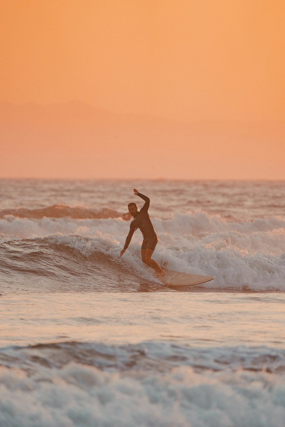 a man riding a wave on top of a surfboard